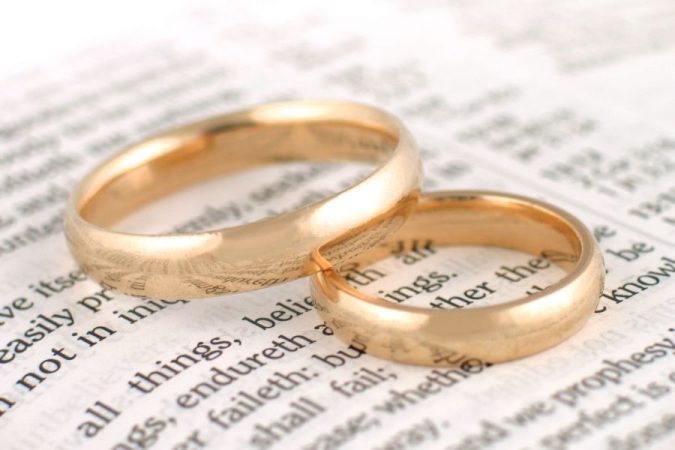 Alliances en or recyclé posées sur un livre pour un mariage écoresponsable