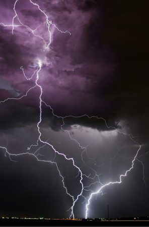 Une image de foudre spectaculaire éclairant un ciel d'orage violet foncé, montrant la puissance de la nature et l'importance des outils météo IA pour l'analyse des tempêtes.