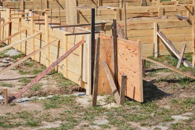 Un coffrage en bois robuste installé sur un chantier pour couler les fondations en béton.