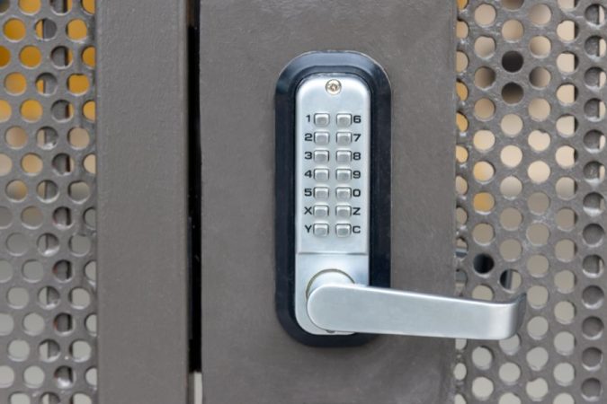Gros plan sur le clavier d'une serrure codée intégrée à une gâche électrique sur une porte d'immeuble